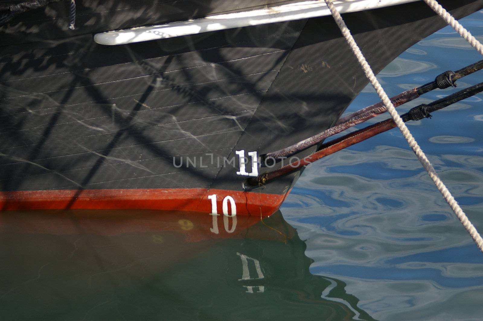 A close up of ships bow showing rigging and water depth.