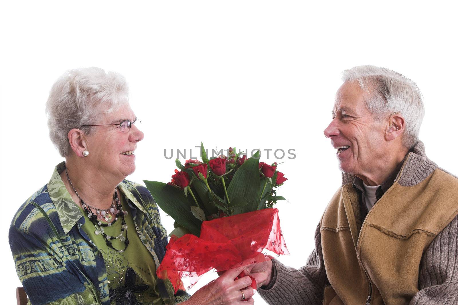 Happy senior couple; the man is giving his wife a lovely bouquet