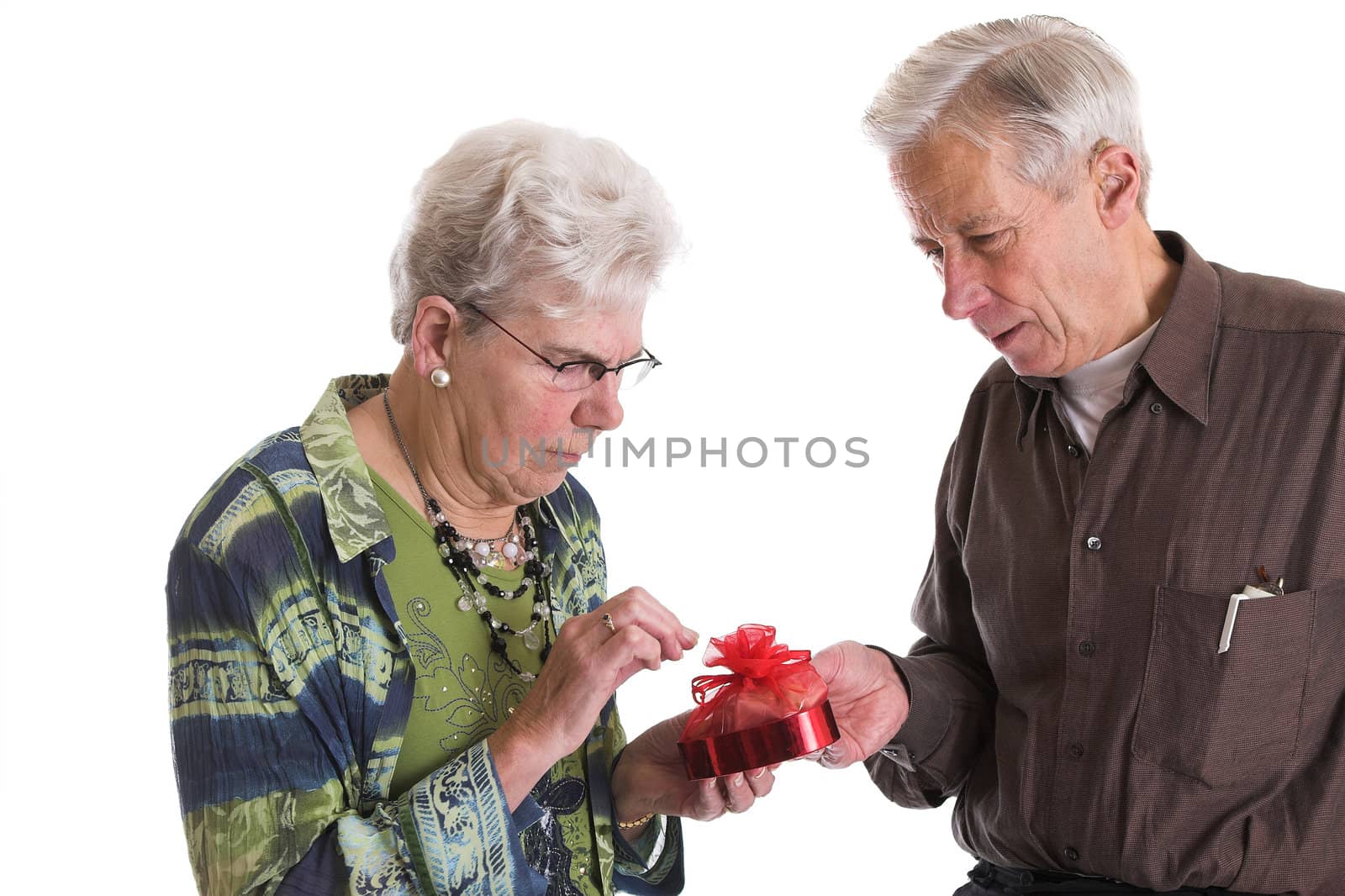 Man helping his wife opening the little strings of the chocolate present he has given her for valentine