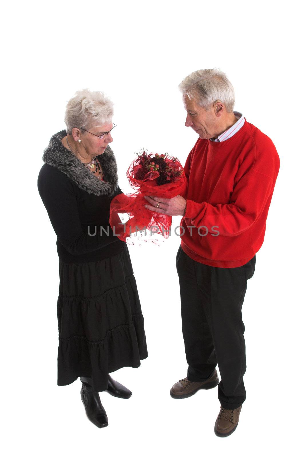 Senior couple during valentine; the man is giving his wife a nice valentine bouquet of flowers