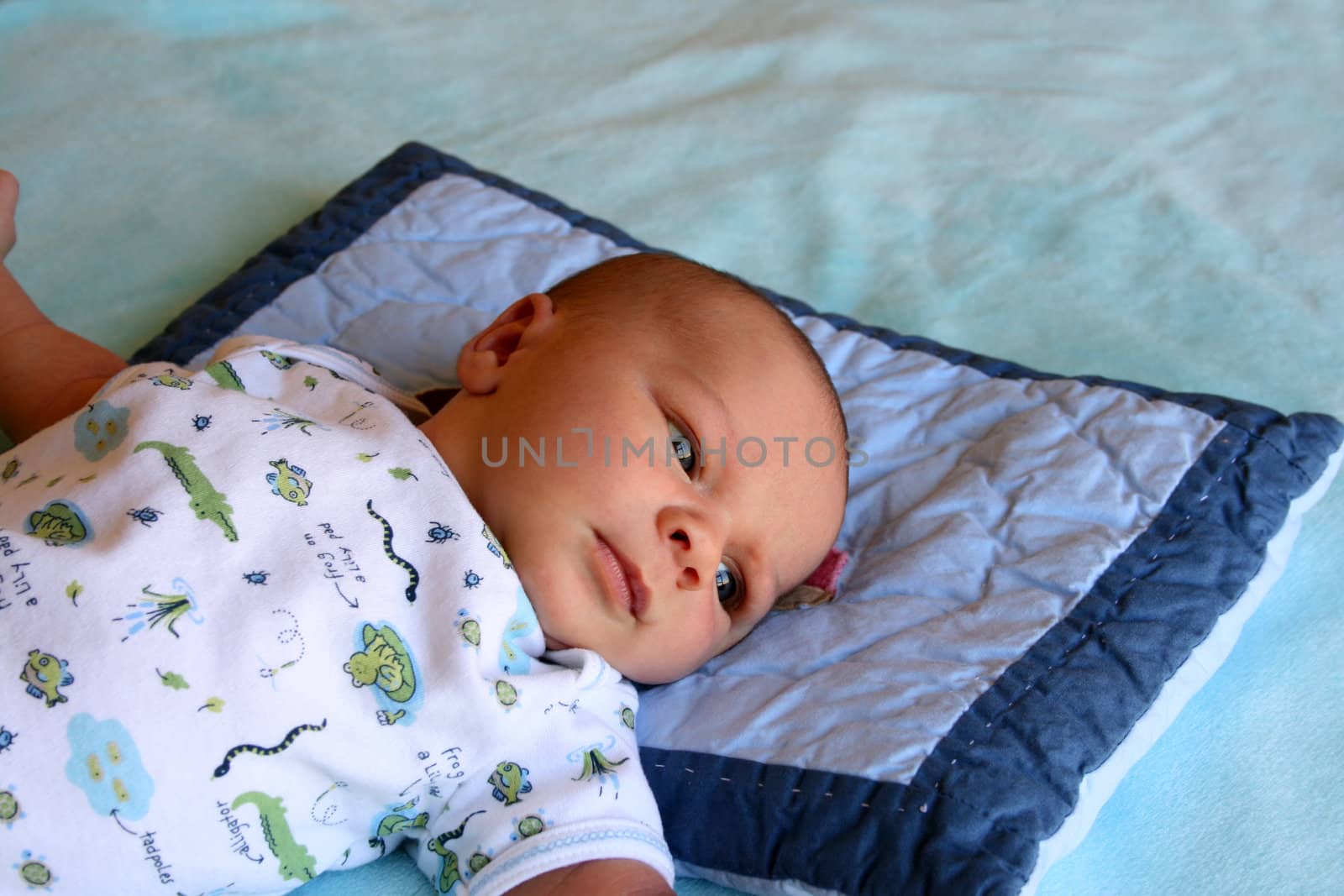 Week old baby boy on a blue blanket early in the morning