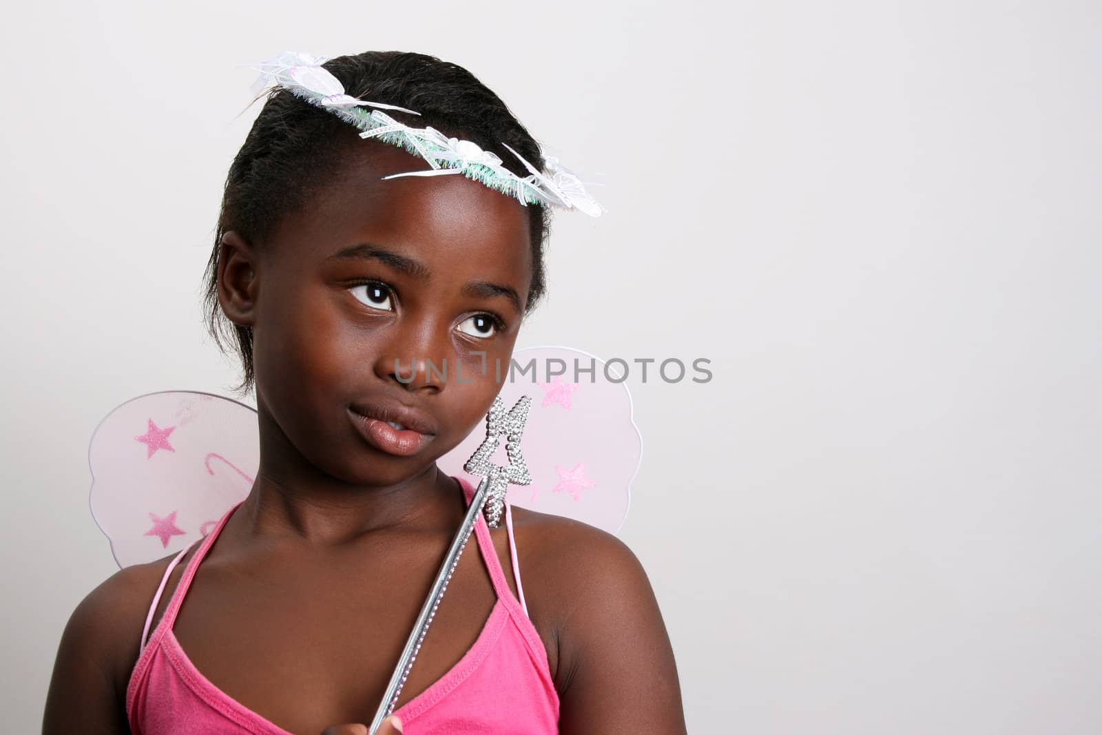 Young girl wearing a pink fairy costume with accessories