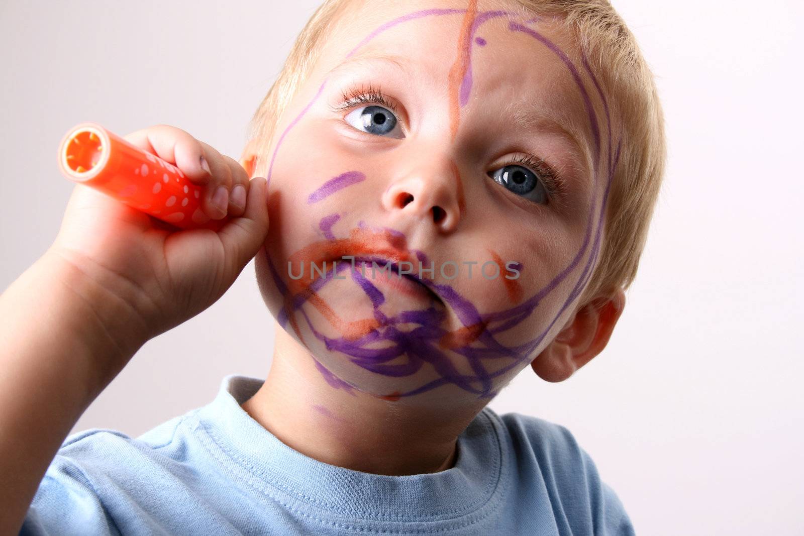 Laughing Toddler playing with colored pens making a mess