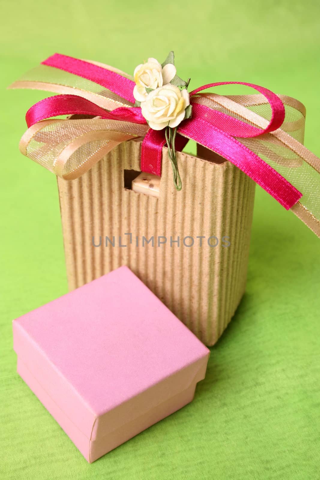 Pink gift box and brown gift bag with ribbons