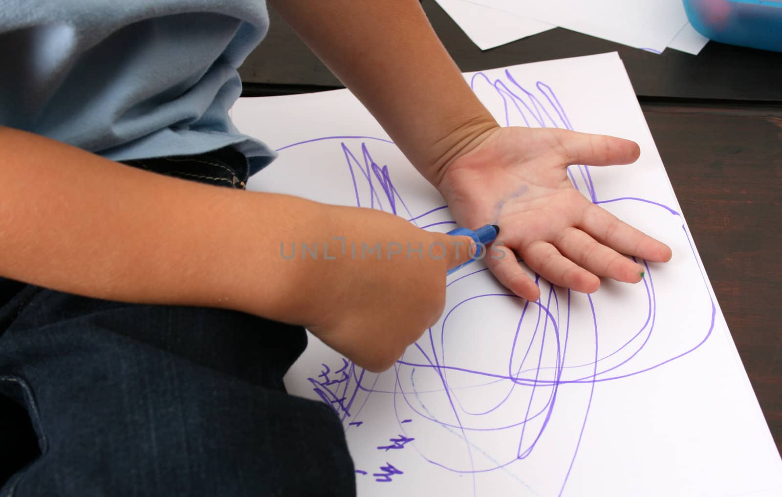 Toddler trying to draw a print of his hand