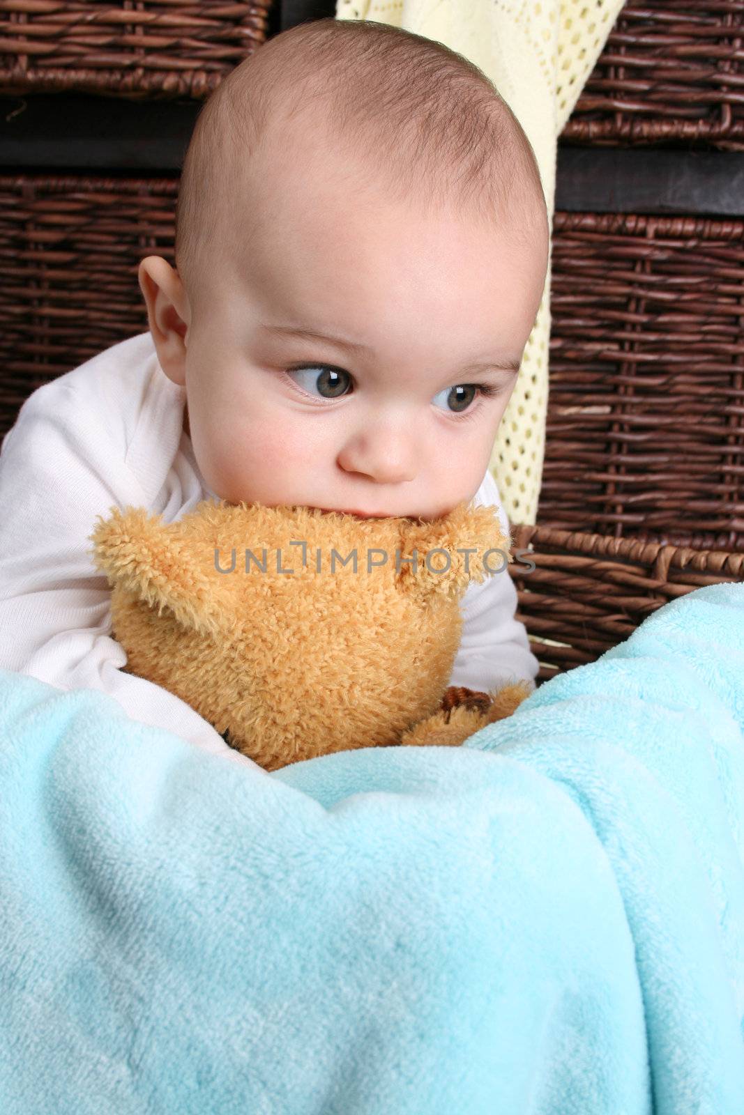 Six month old baby sitting infront of wooden drawers