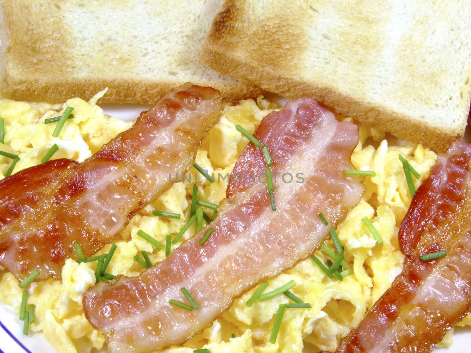 Close-up of scrambled eggs with bacon strips and toast