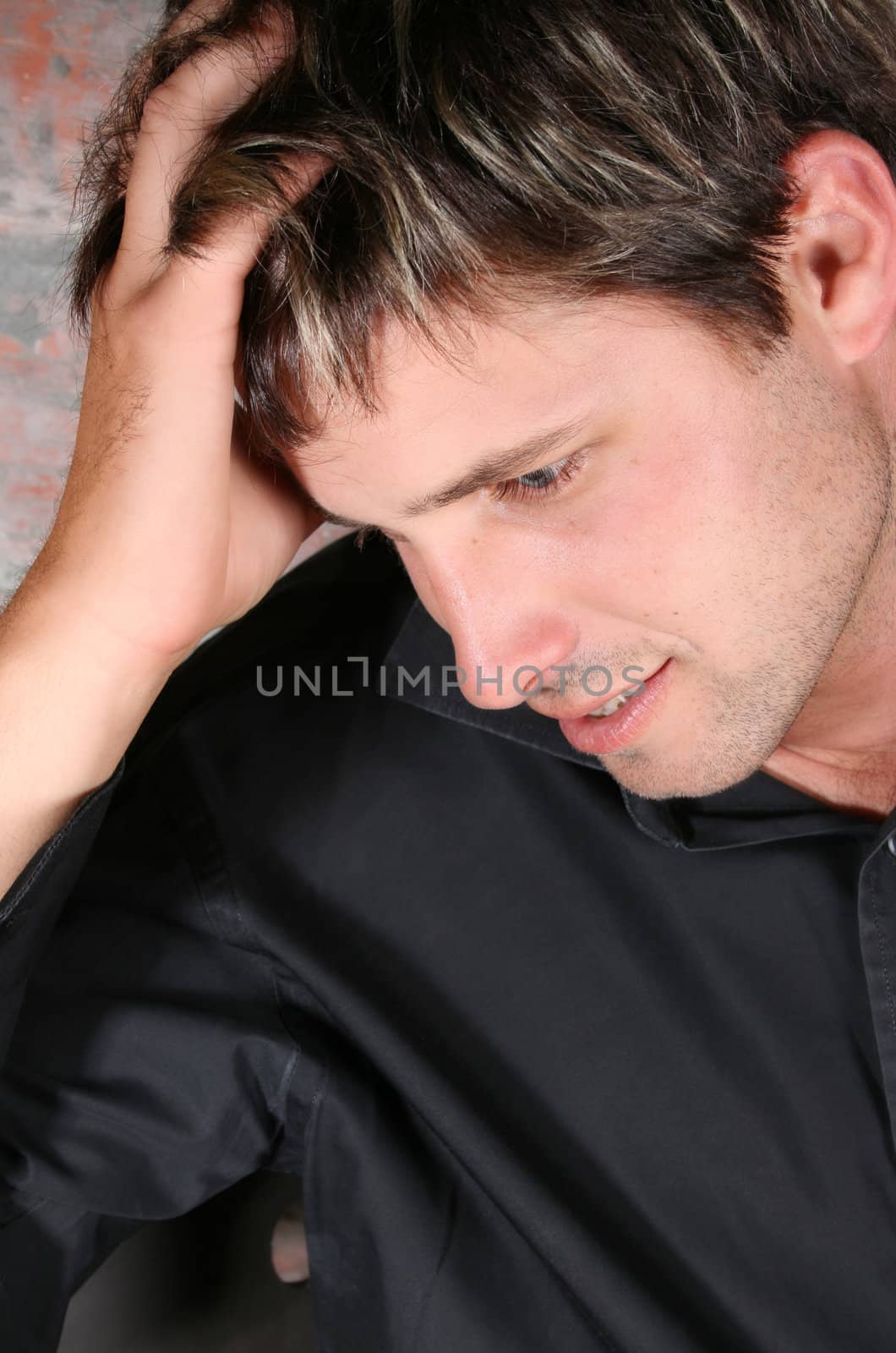 Male model against a rough brick wall background