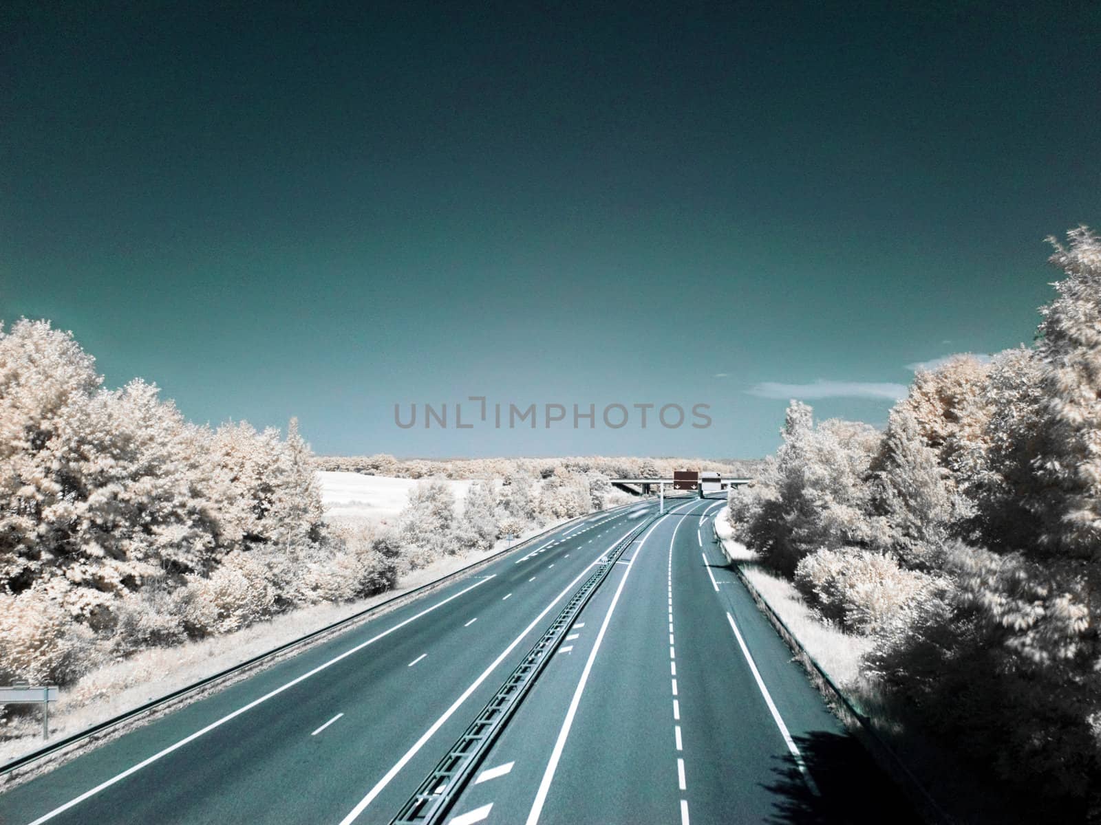 Infrared picture of an empty highway with blue sky