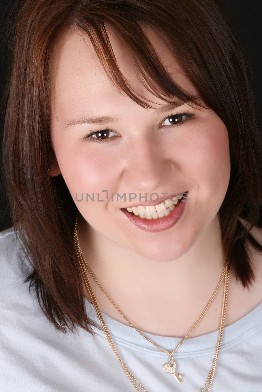Headshot of beautiful brunette female on a black background 
