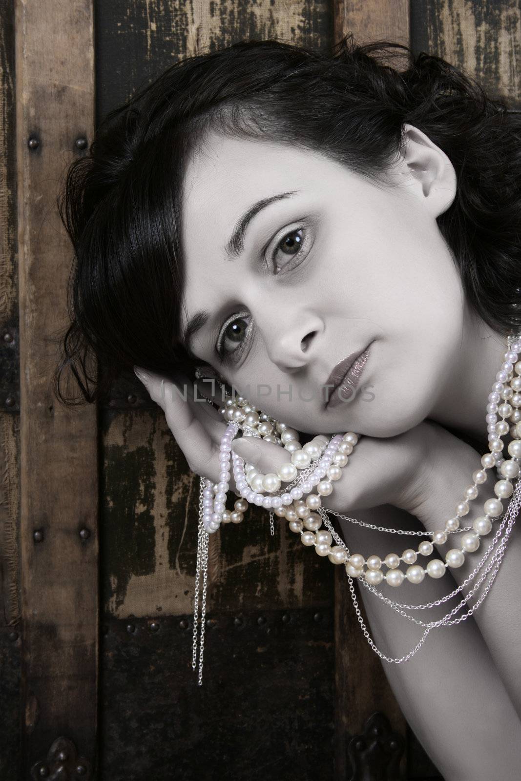 Beautiful brunette against a rugged antique chest with jewellery