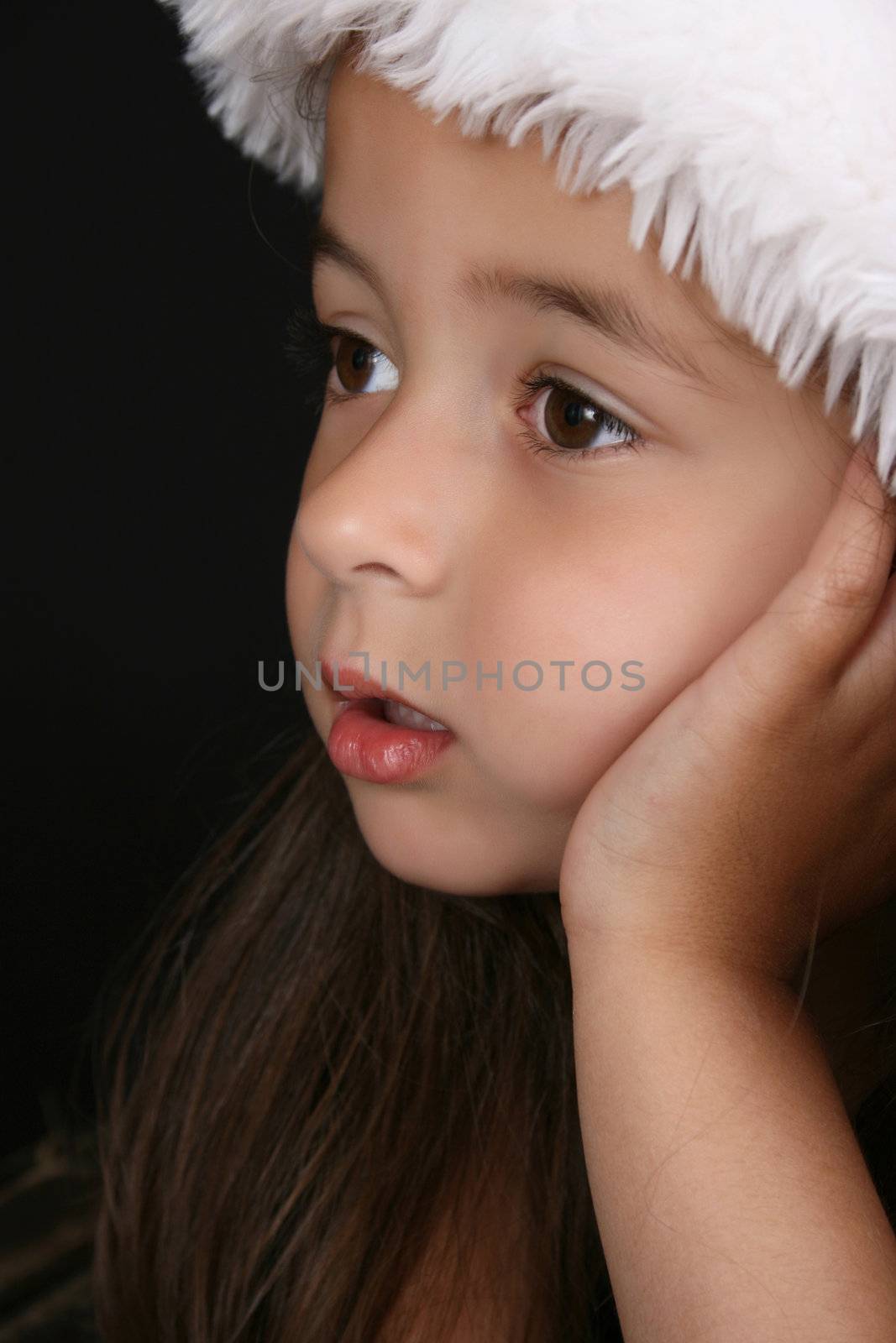 Cute little brunette girl wearing a christmas hat 