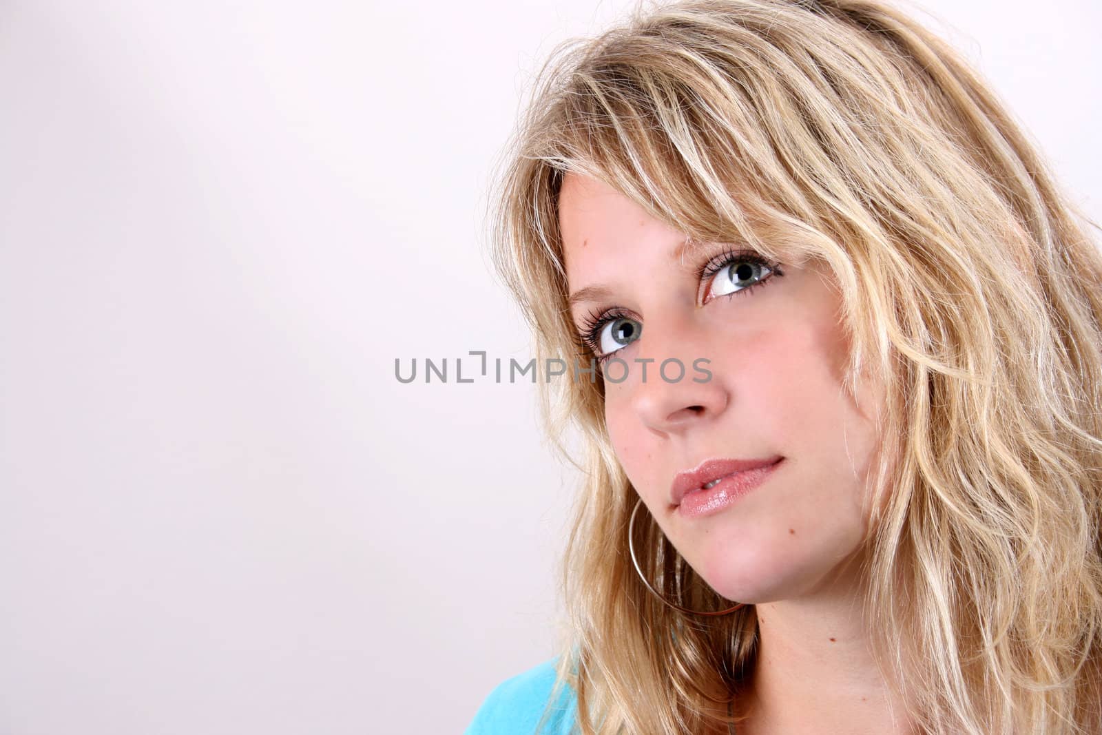 Blond Female model on a white background wearing a blue top