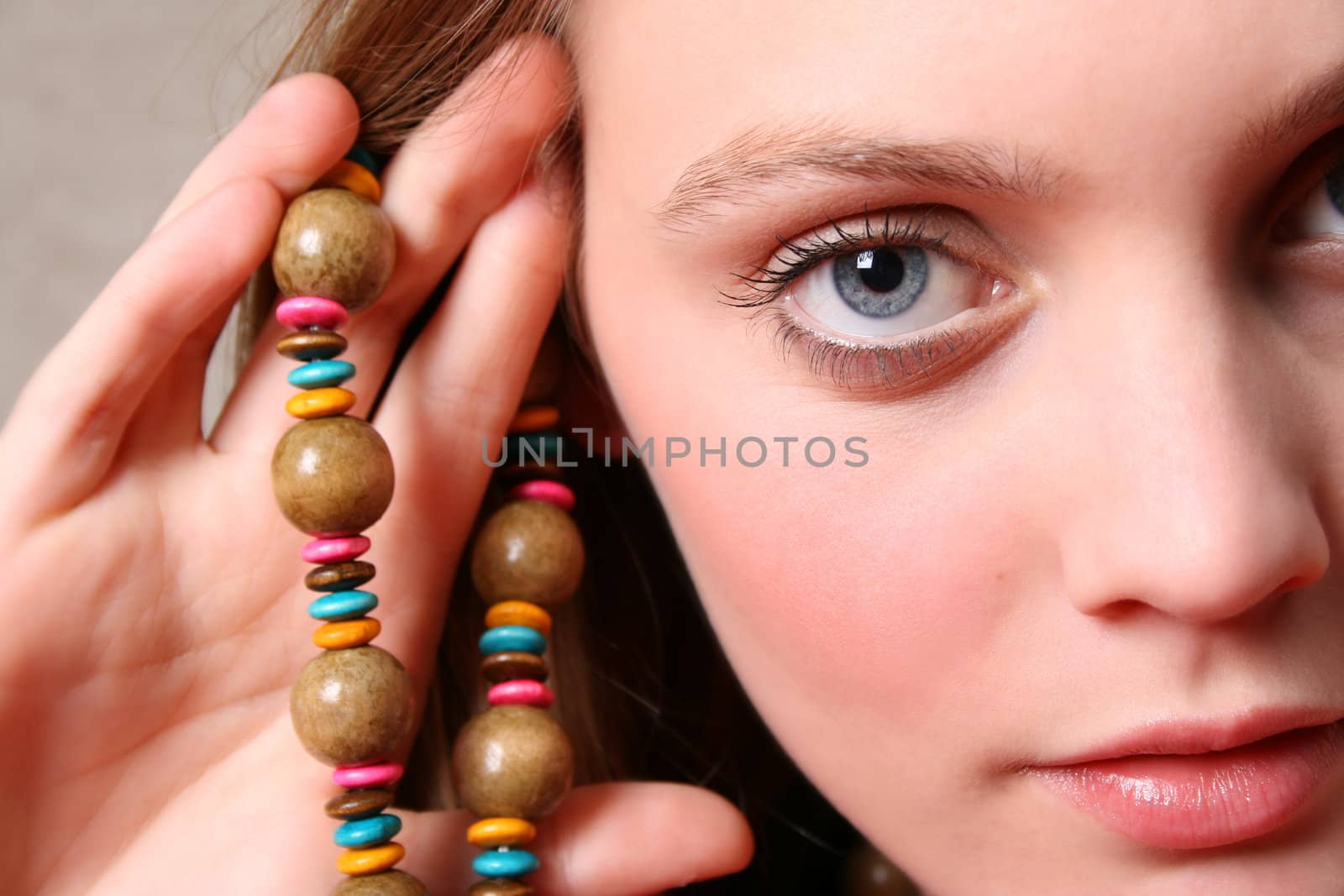 Beautiful female model with blue eyes and a string beads