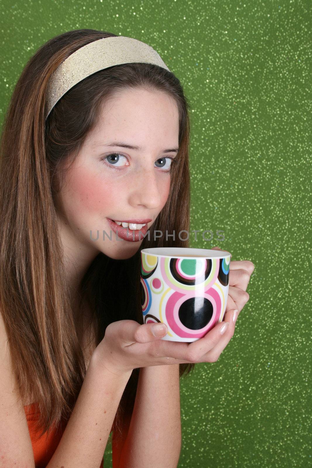 Brunette teenager on a green background wearing a broad head band
