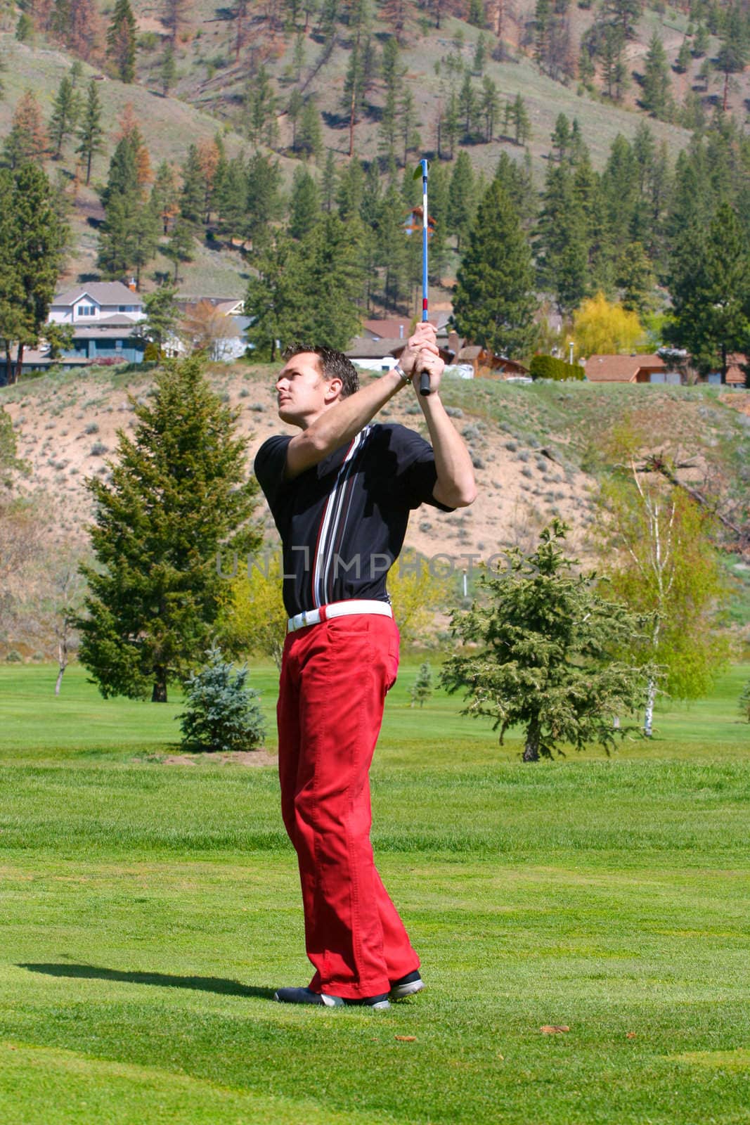 Young golfer following his ball after a shot from the fairway