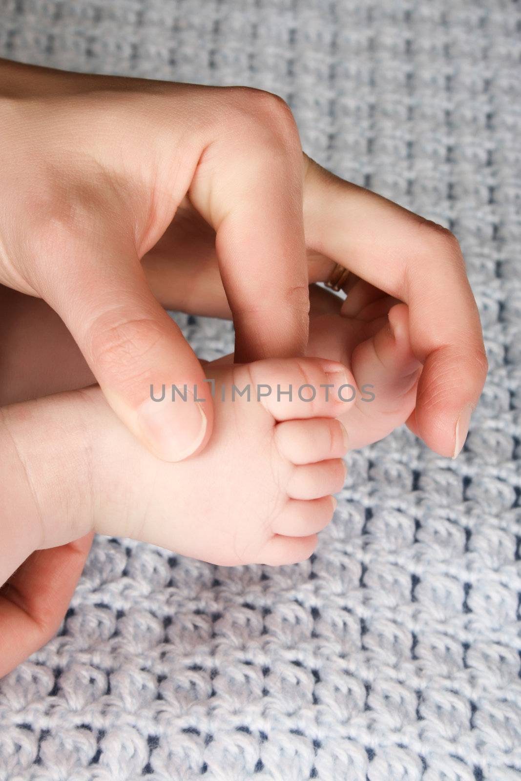 Hands and feet of caucasian mother and baby
