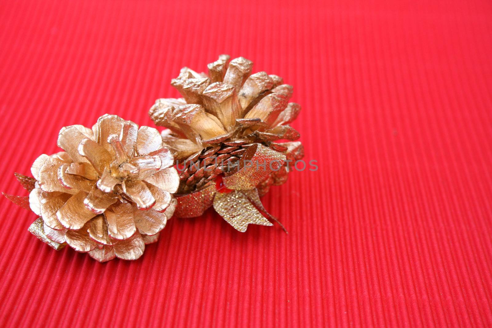 Golden decorated pine cones on a red background