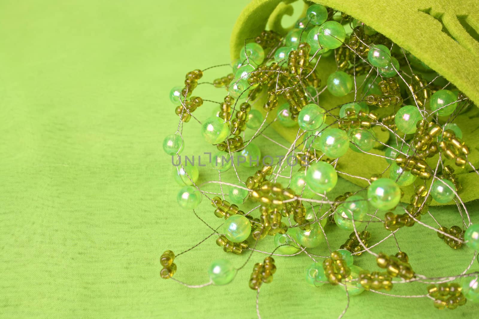 Green beadwork on a green background in a filt cup