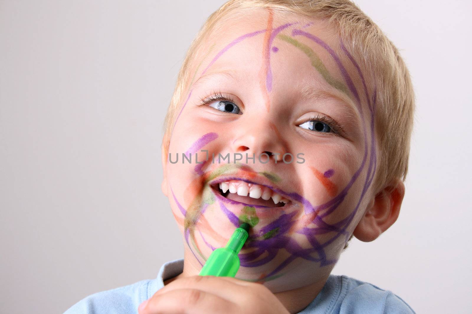 Laughing Toddler playing with colored pens making a mess