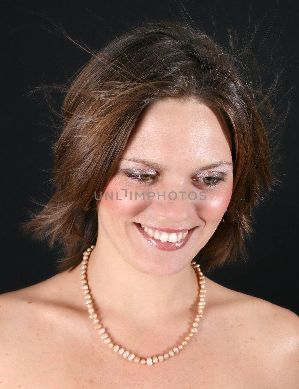 Beautiful young woman with bare shoulders and pearls