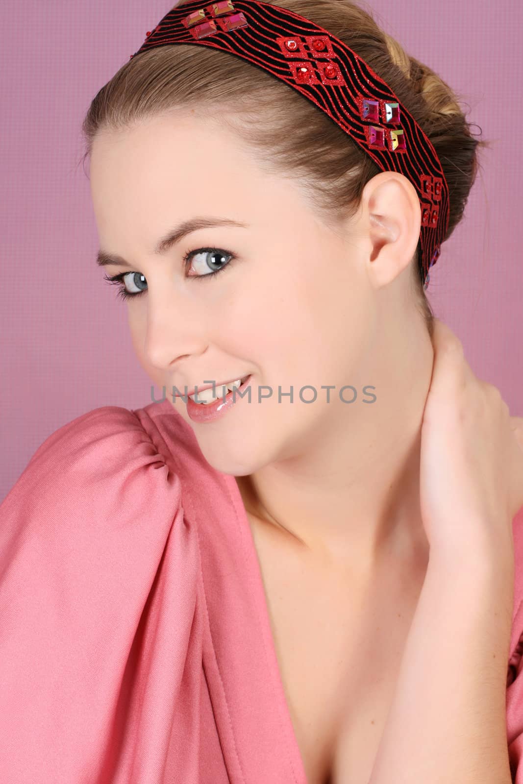 Beautiful blond female model wearing pink dress and hair accessories