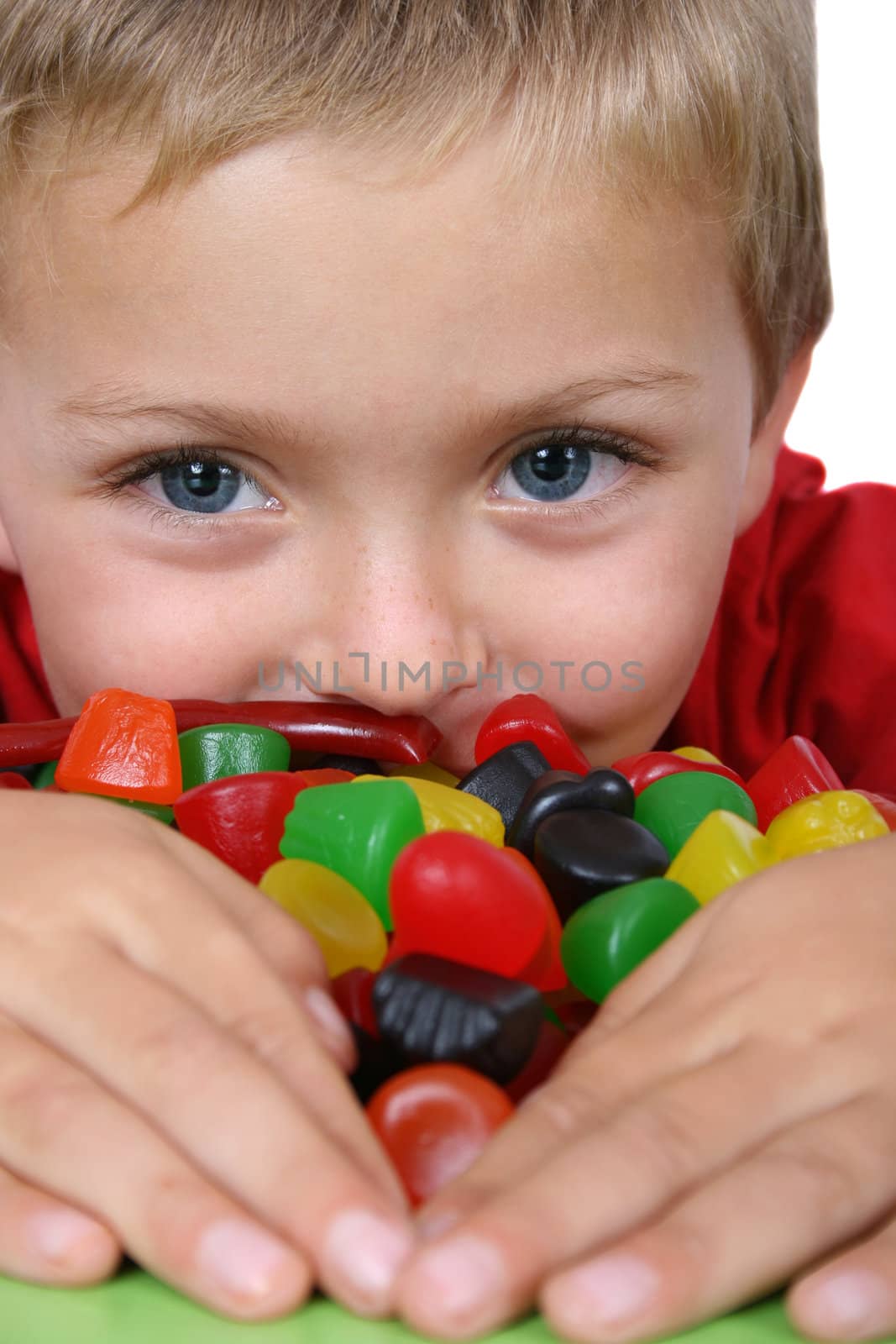 Young boy being with a table full of colorful sweets 
