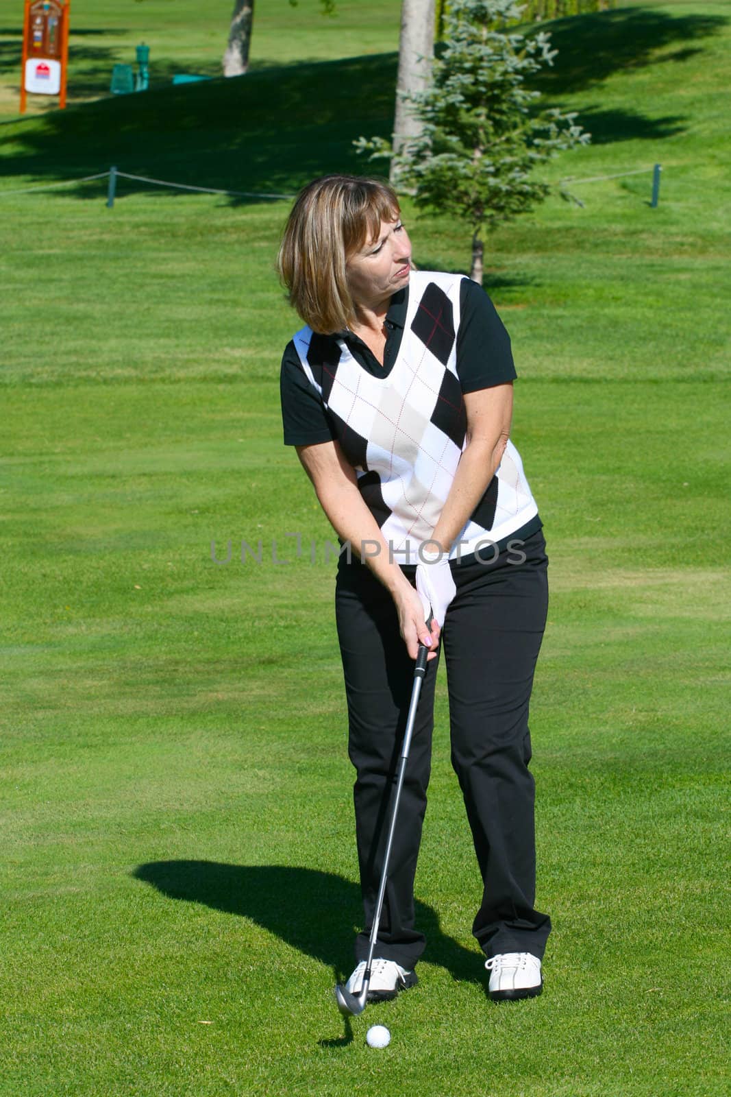 Blond female golfer preparing to play a shot