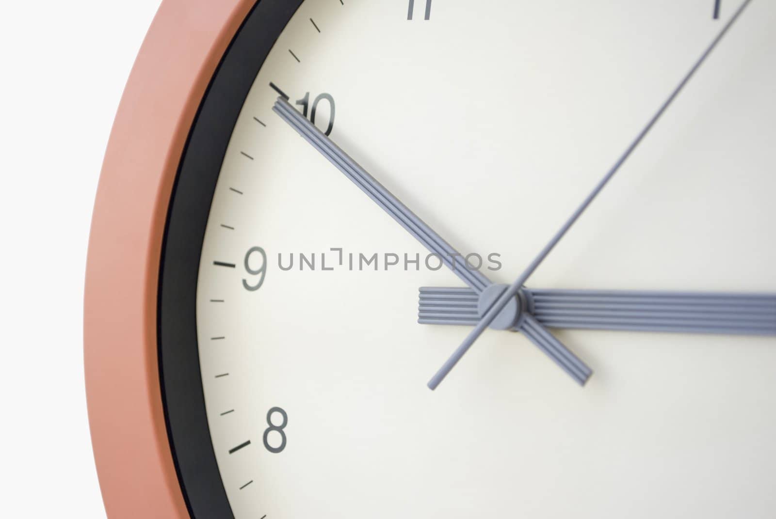 Clock face portion, taken at an angle.  Cream face, black lettering, sans serif typeface.  Grey hands.  Hour, minute and second hands.  Black clock border, and terracotta circular frame.  Pure white background.