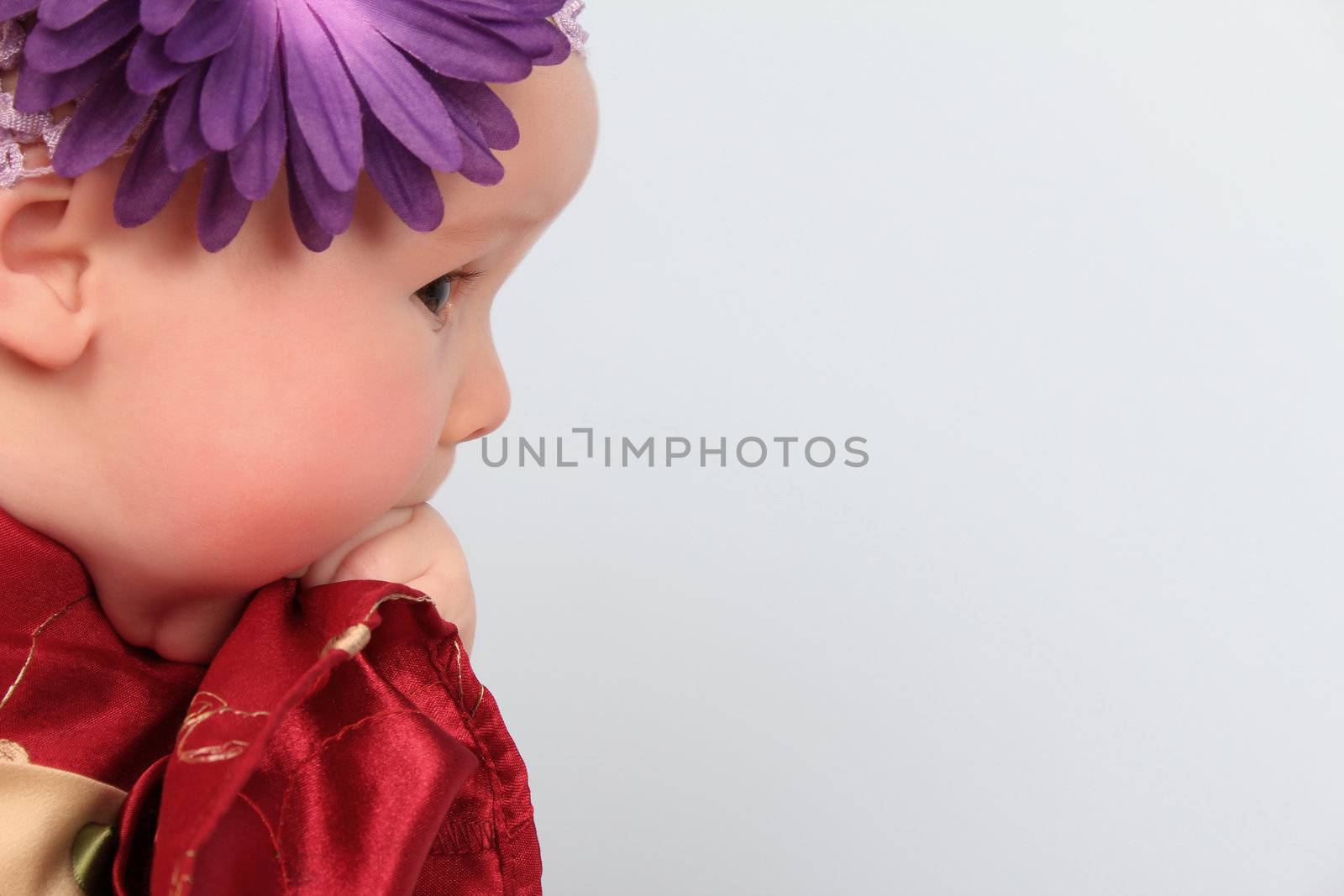 Beautiful baby girl wearing a headband with purple flower