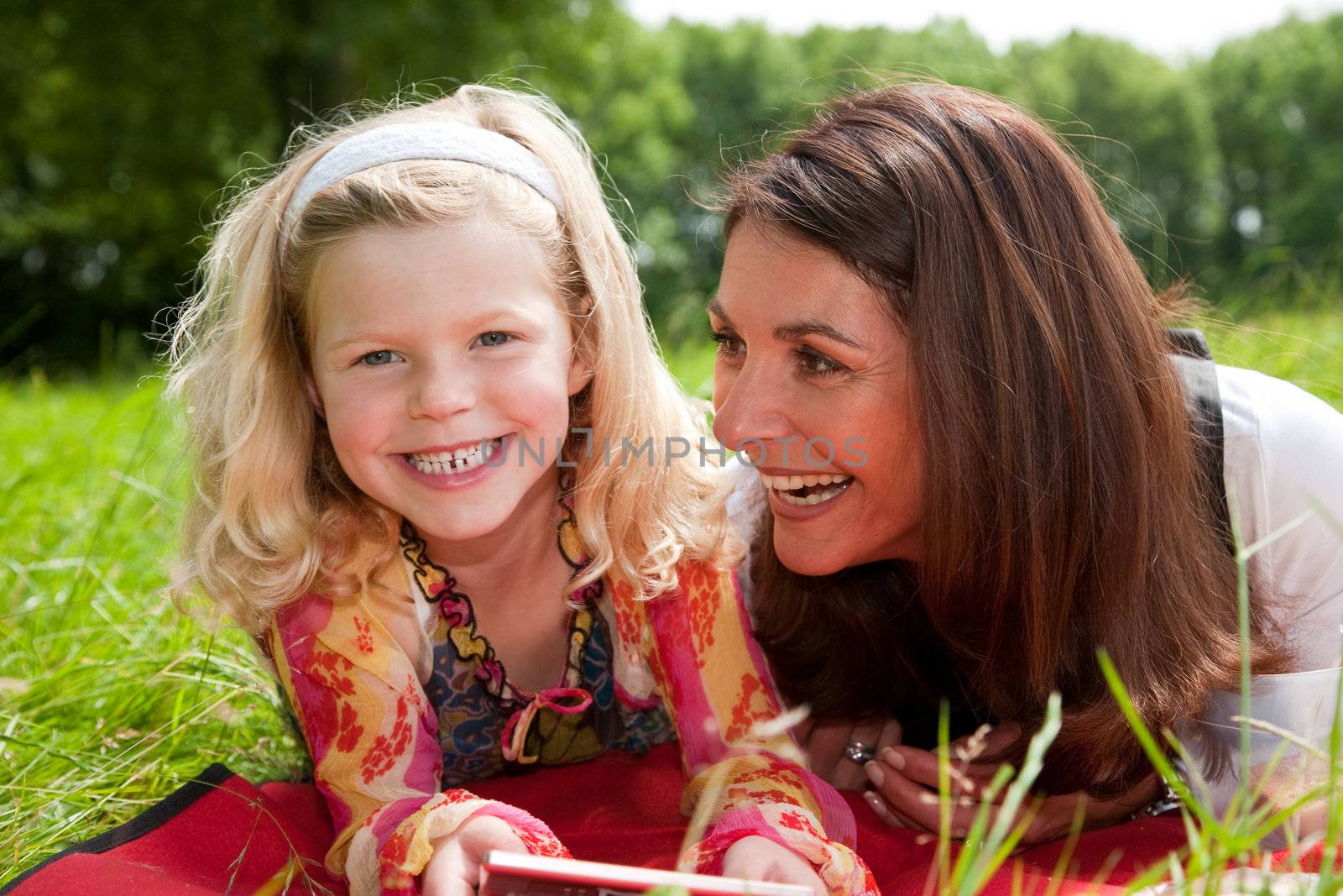 Mother and daughter outdoors together having fun and laughing