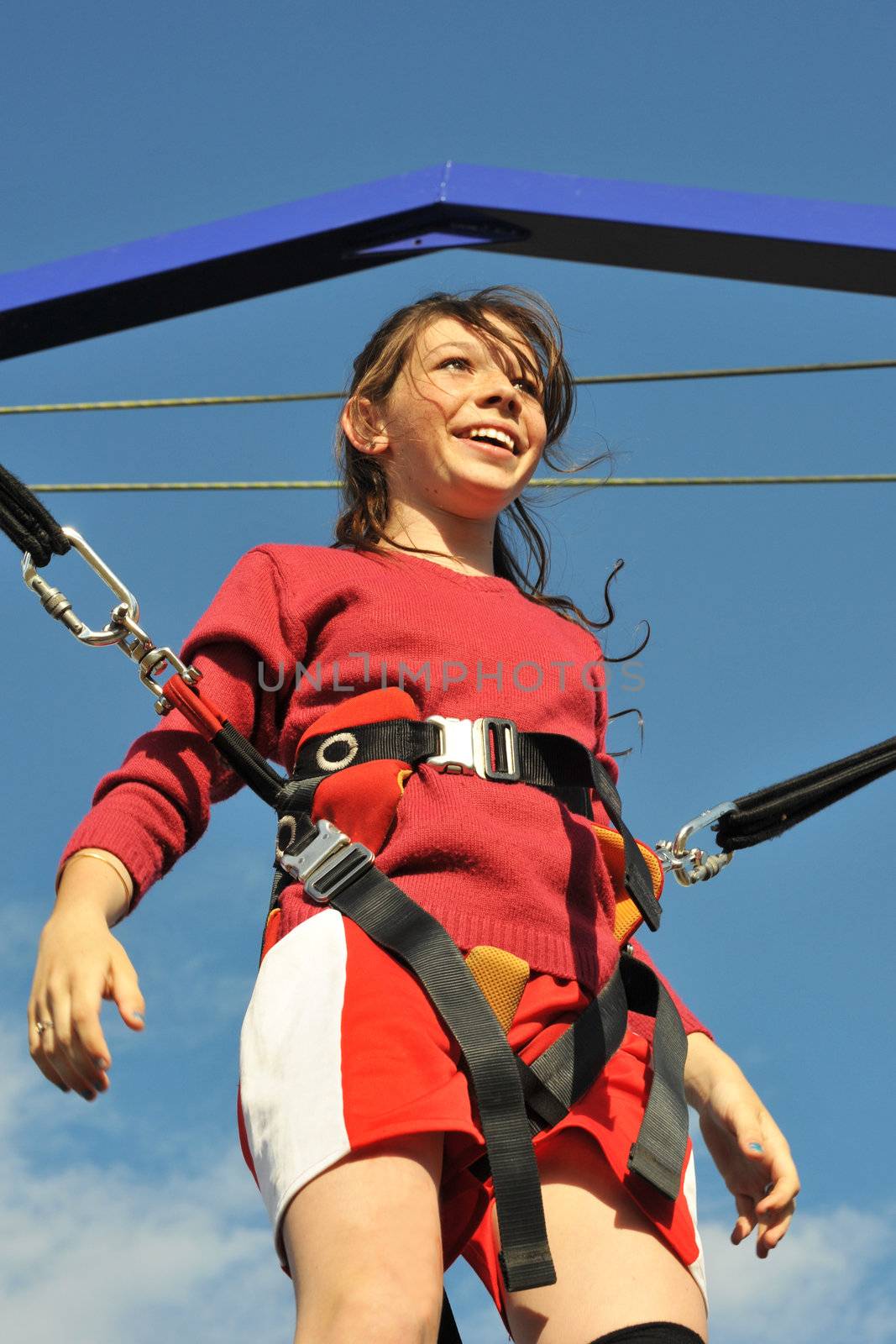 young teenager smiling on the trampoline (bungee jumping).