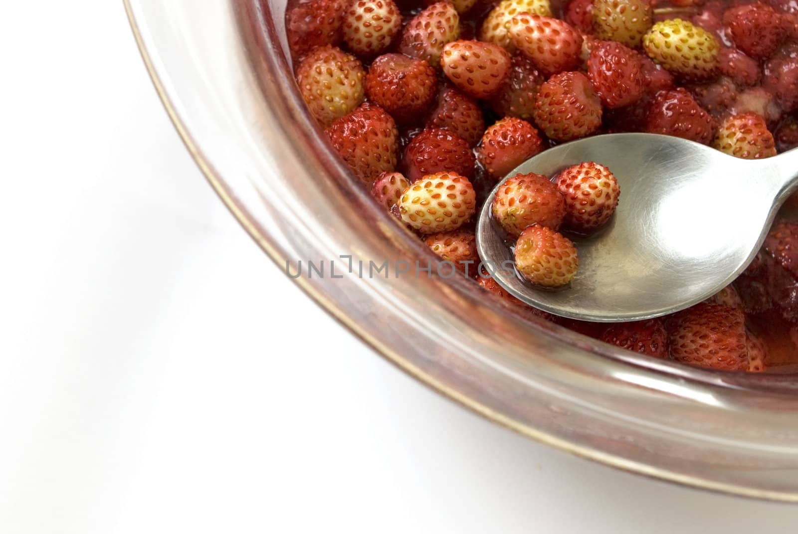 Portion of sweet wild strawberry jam. The spoon is applied