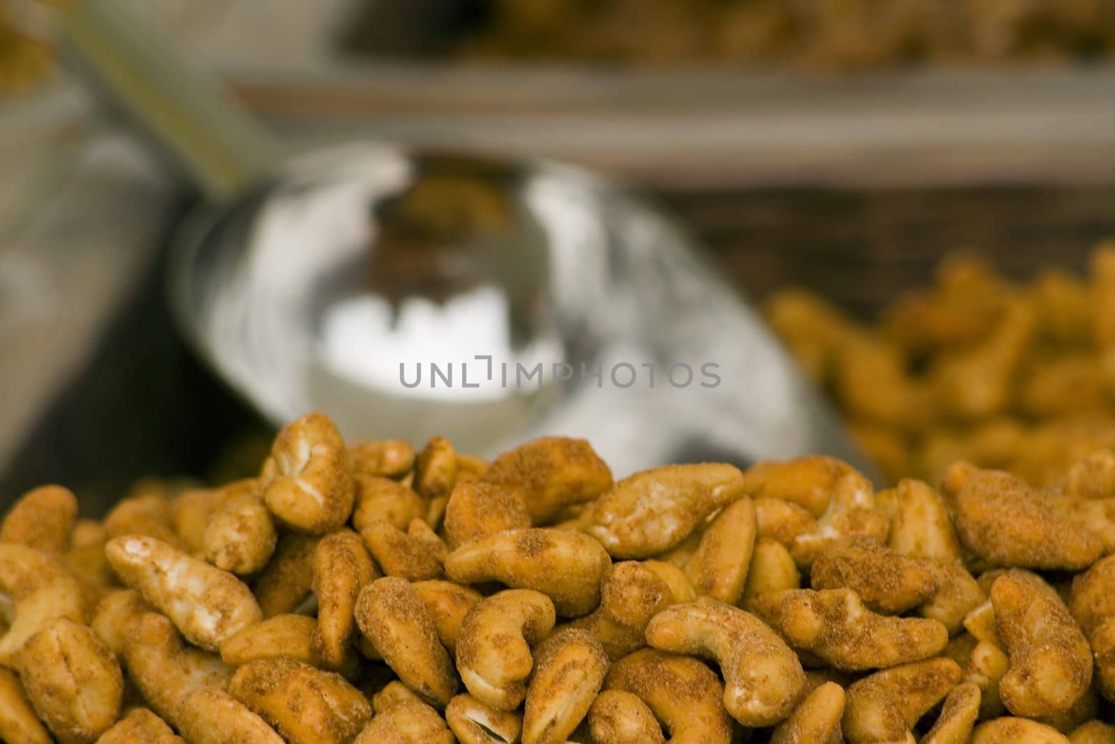 a basket of dry roasted peanuts with a scoop in the background