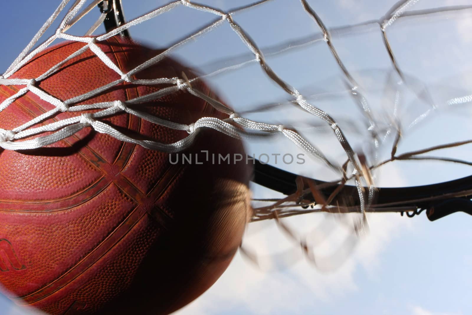 Picture of a basketball field goal with the sky in background.