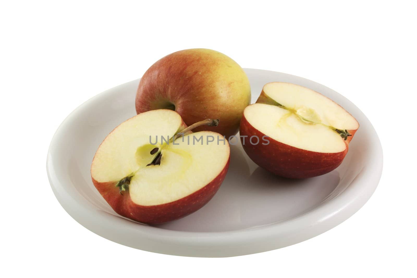 A plate with two apples on it, one cut and the other whole