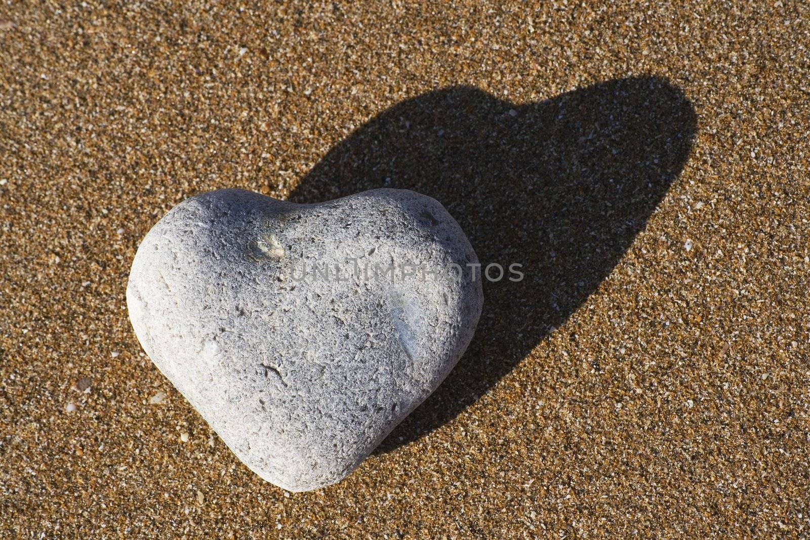 A heart shaped stone on a sandy beach