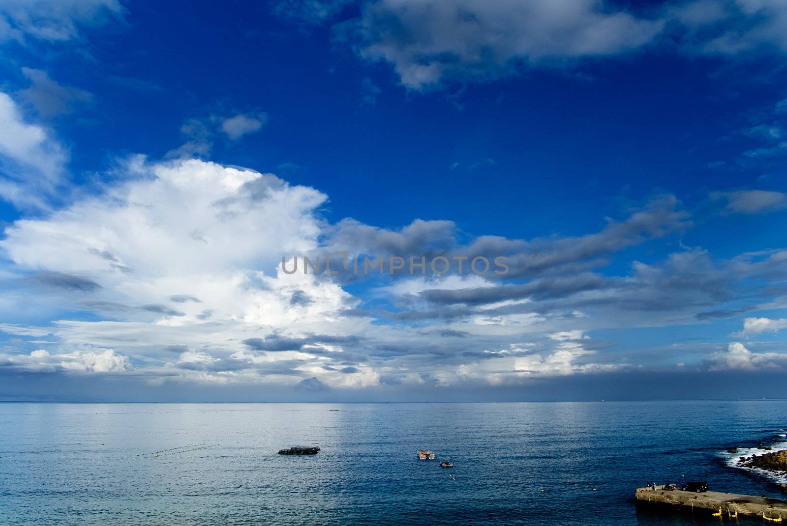 It is beautiful sky and ocean with fishing boats.