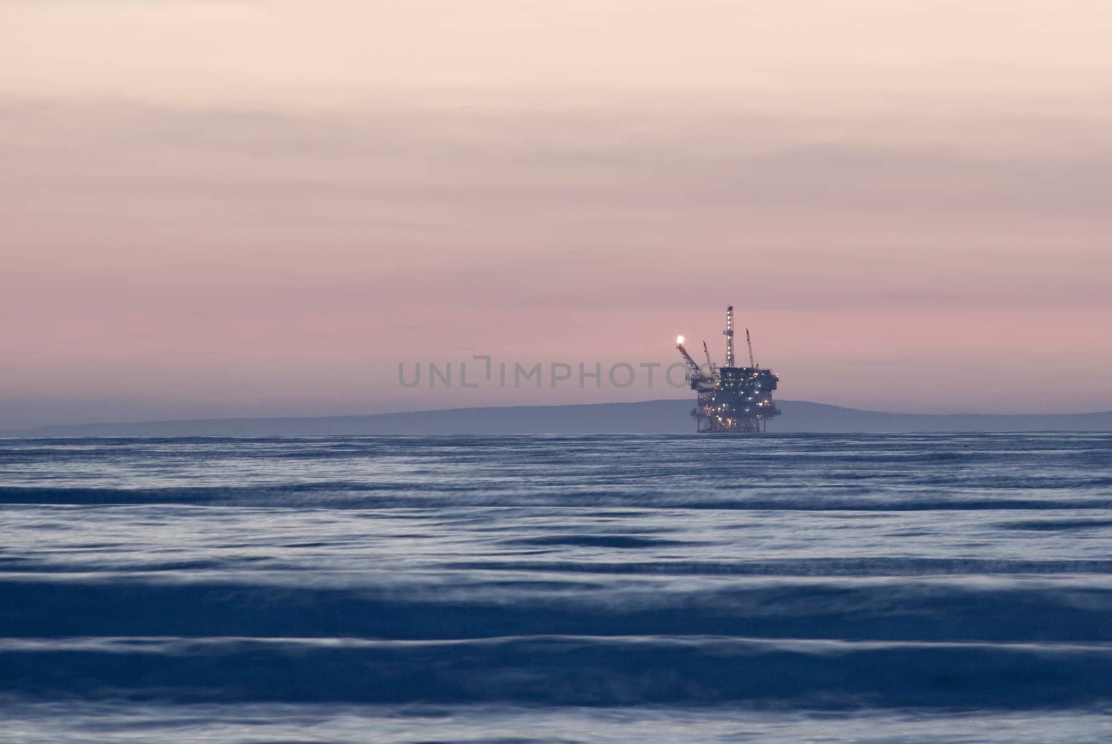and off shore oil drilling platform at sunset