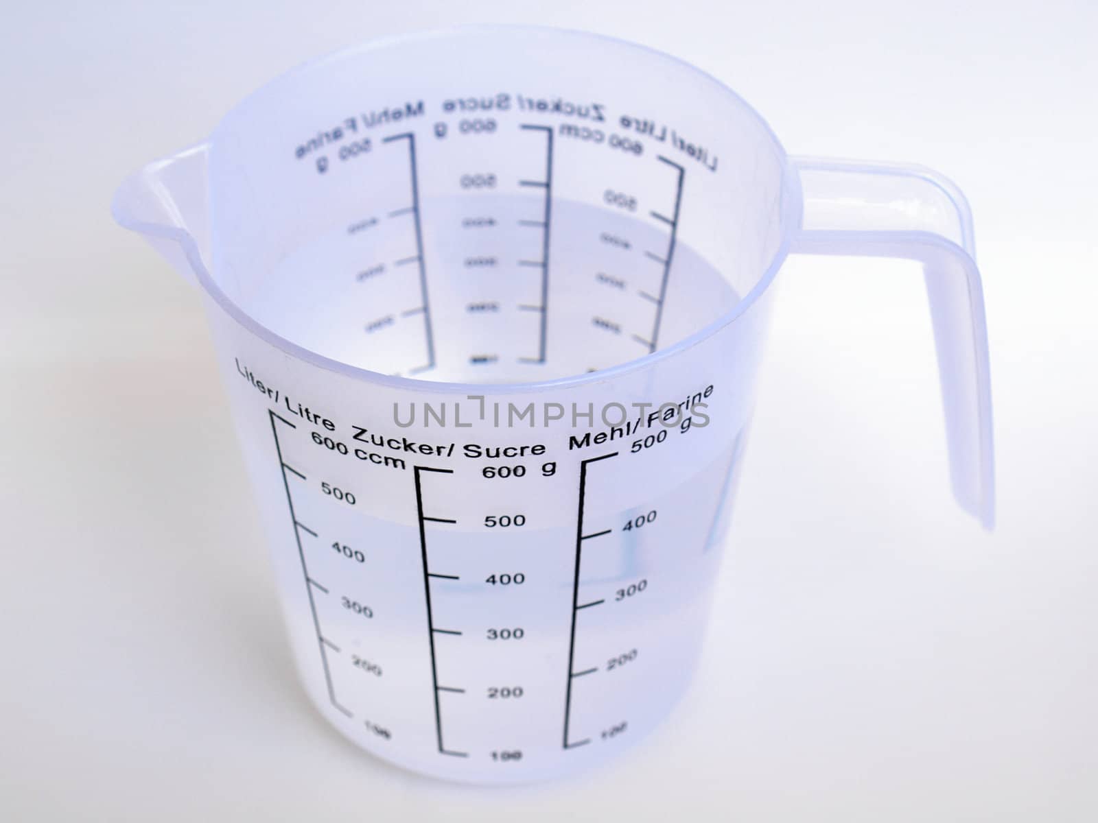 Measuring cup with metric scales for water, sugar and flour
