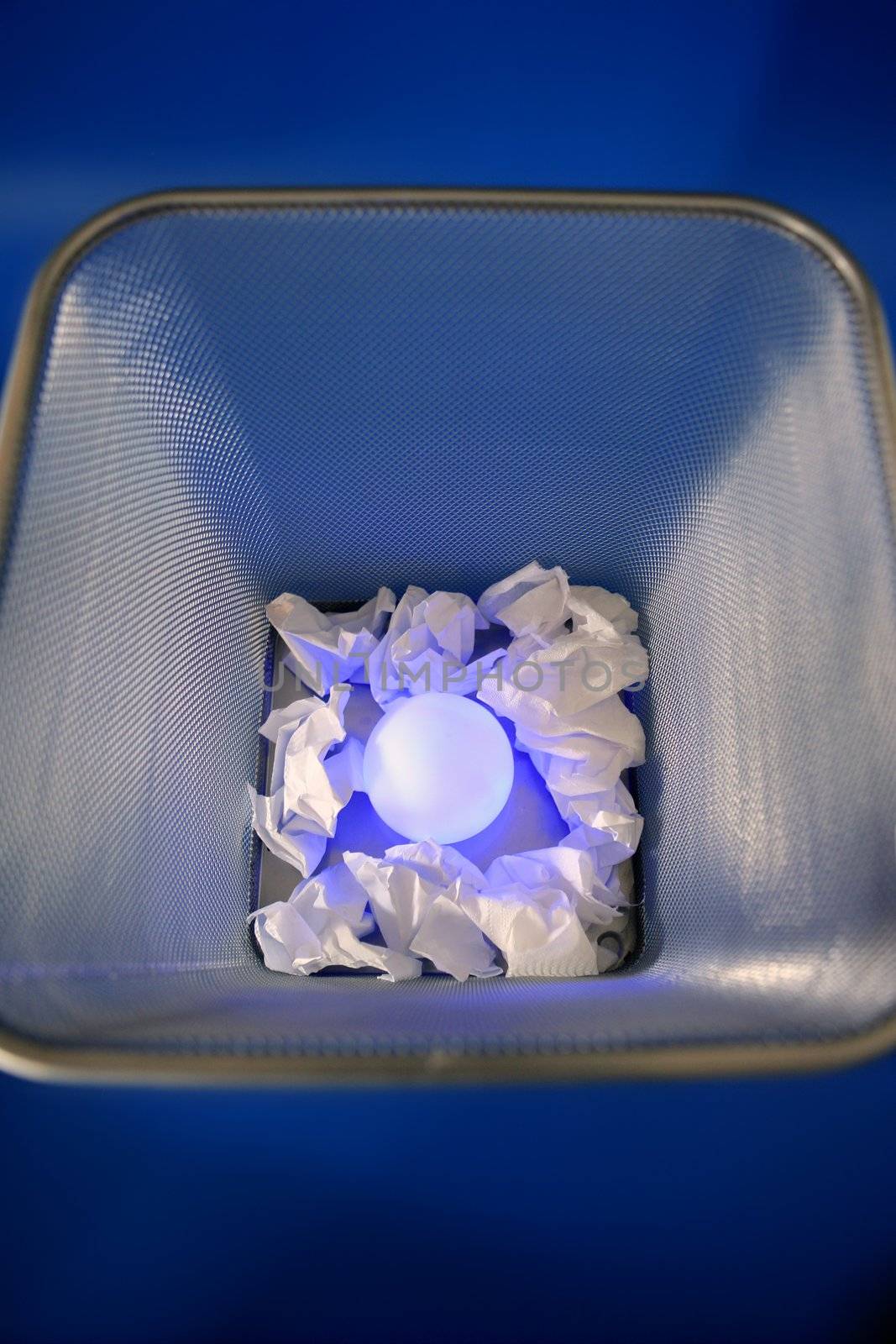 Glowing light sphere on the paper office trash, business metaphor