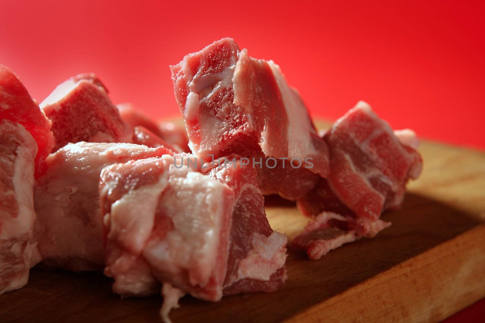 Pig, pork raw meat pieces over red background