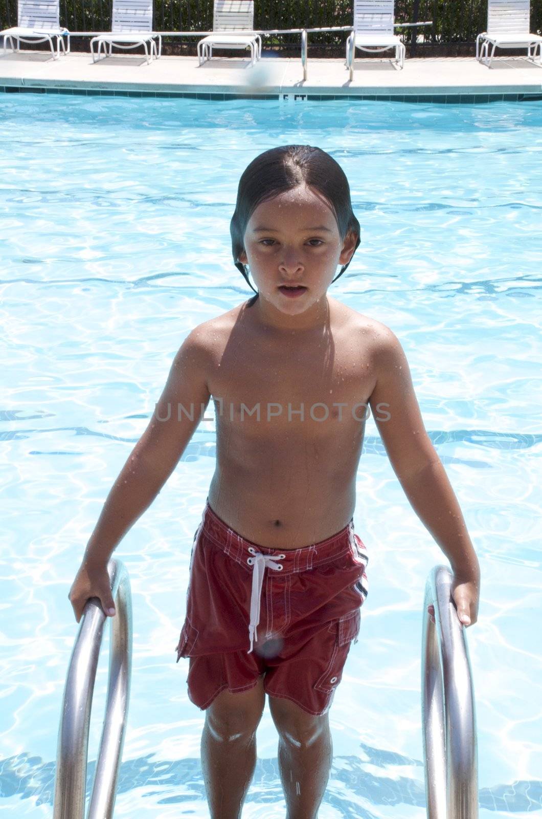 Little boy having fun at neighborhood pool by jedphoto