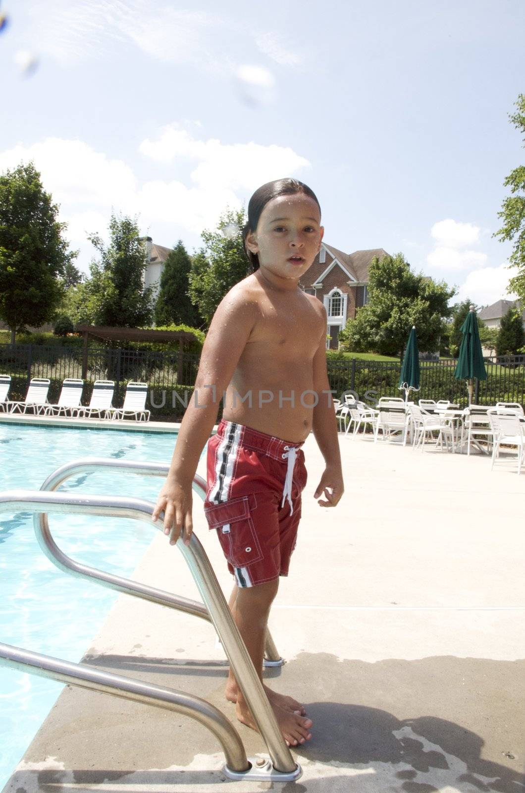 Little boy having fun at neighborhood pool by jedphoto