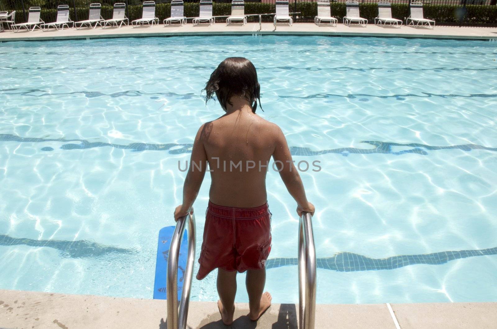 Little boy having fun at neighborhood pool by jedphoto