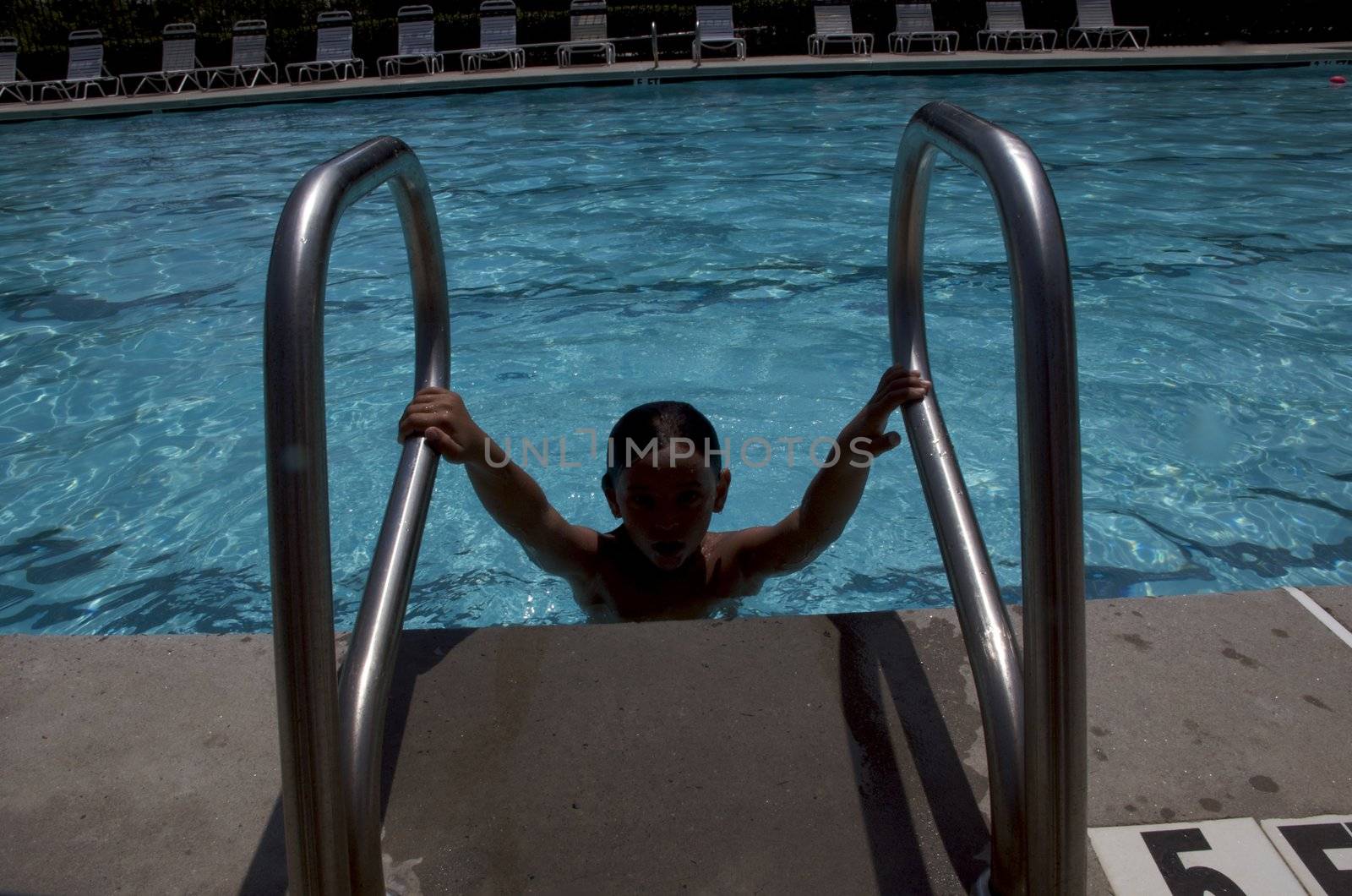 Little boy having fun at neighborhood pool by jedphoto