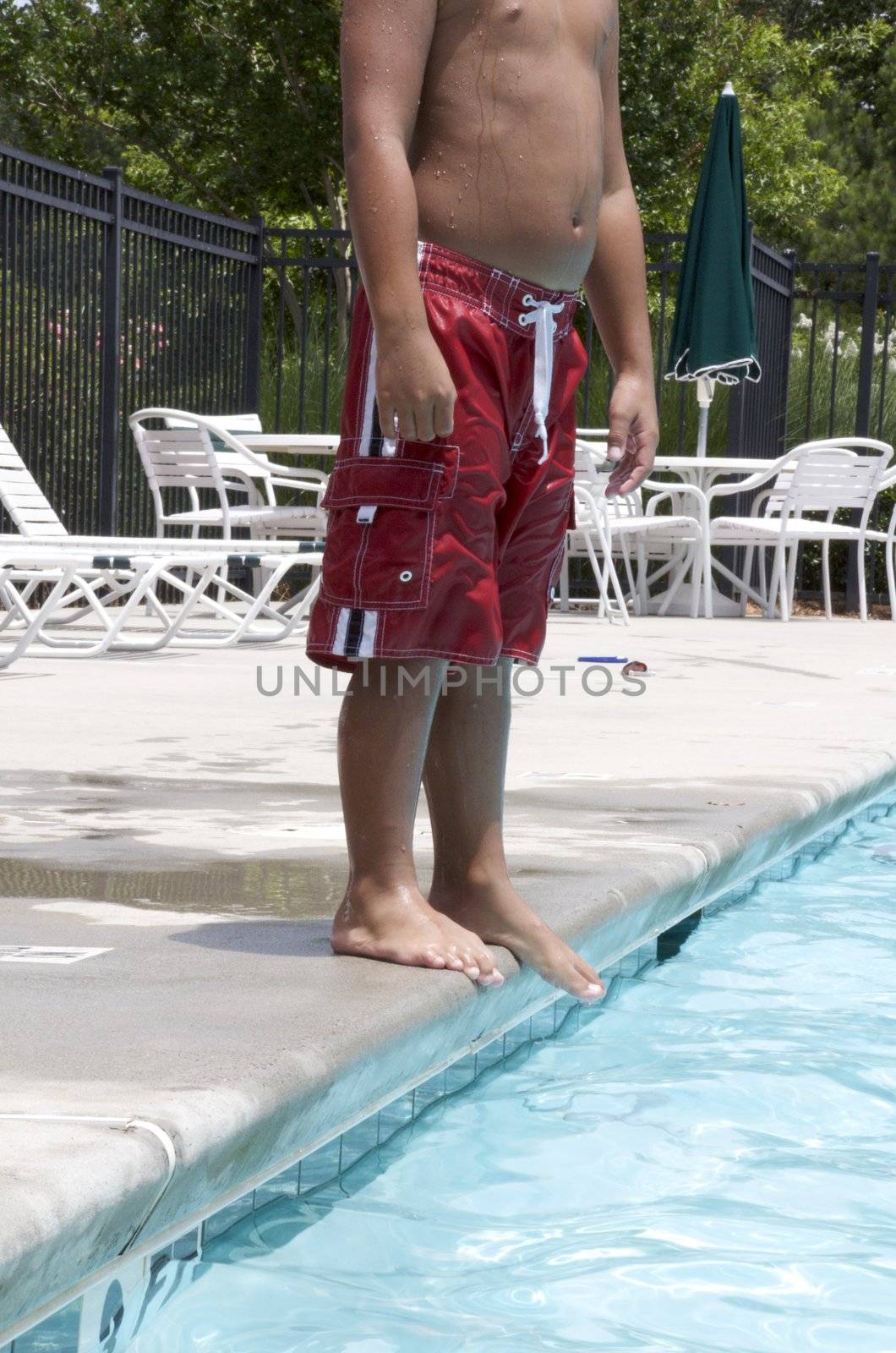 Little boy having fun at neighborhood pool by jedphoto