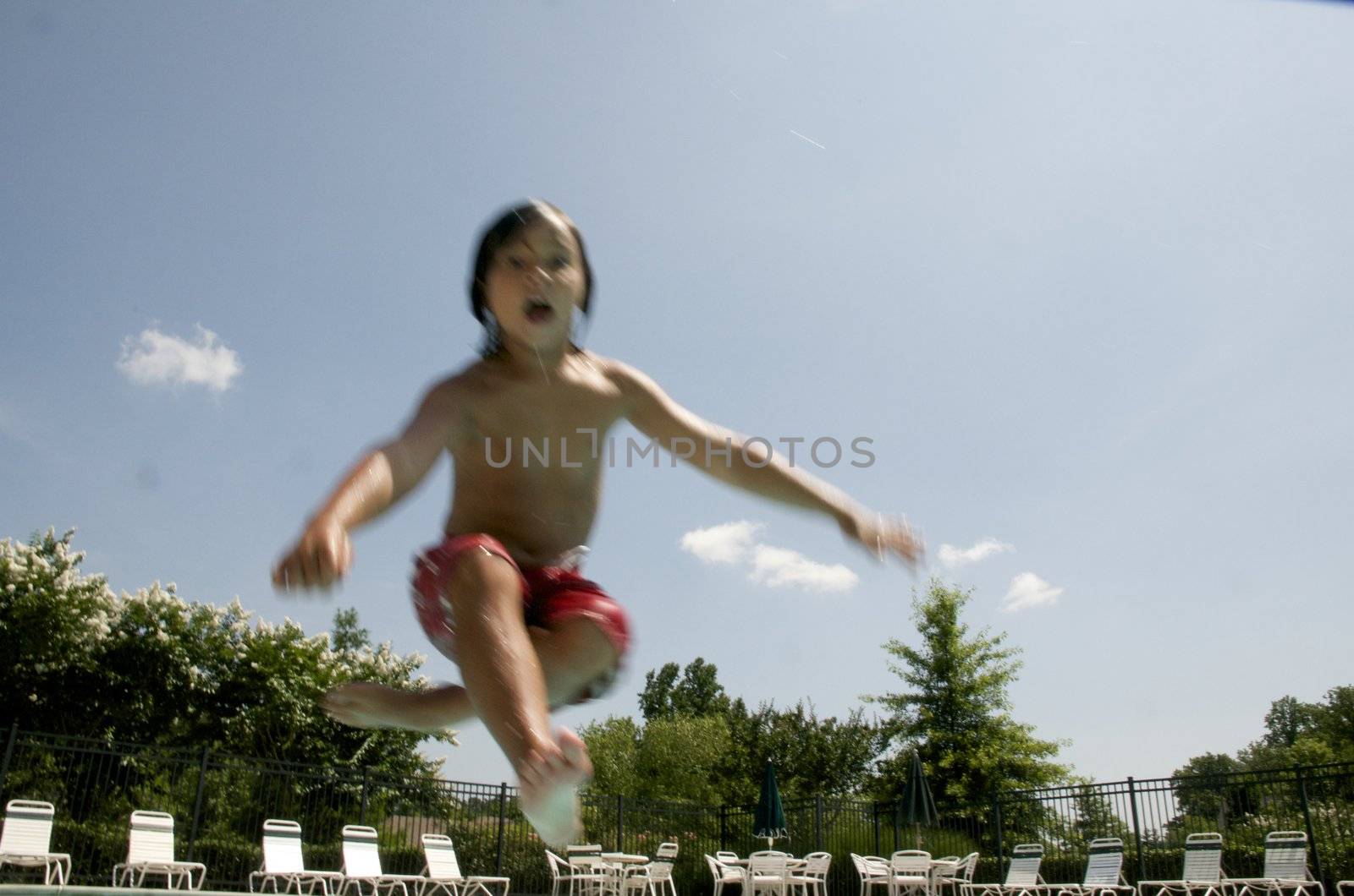 Little boy jumping into pool