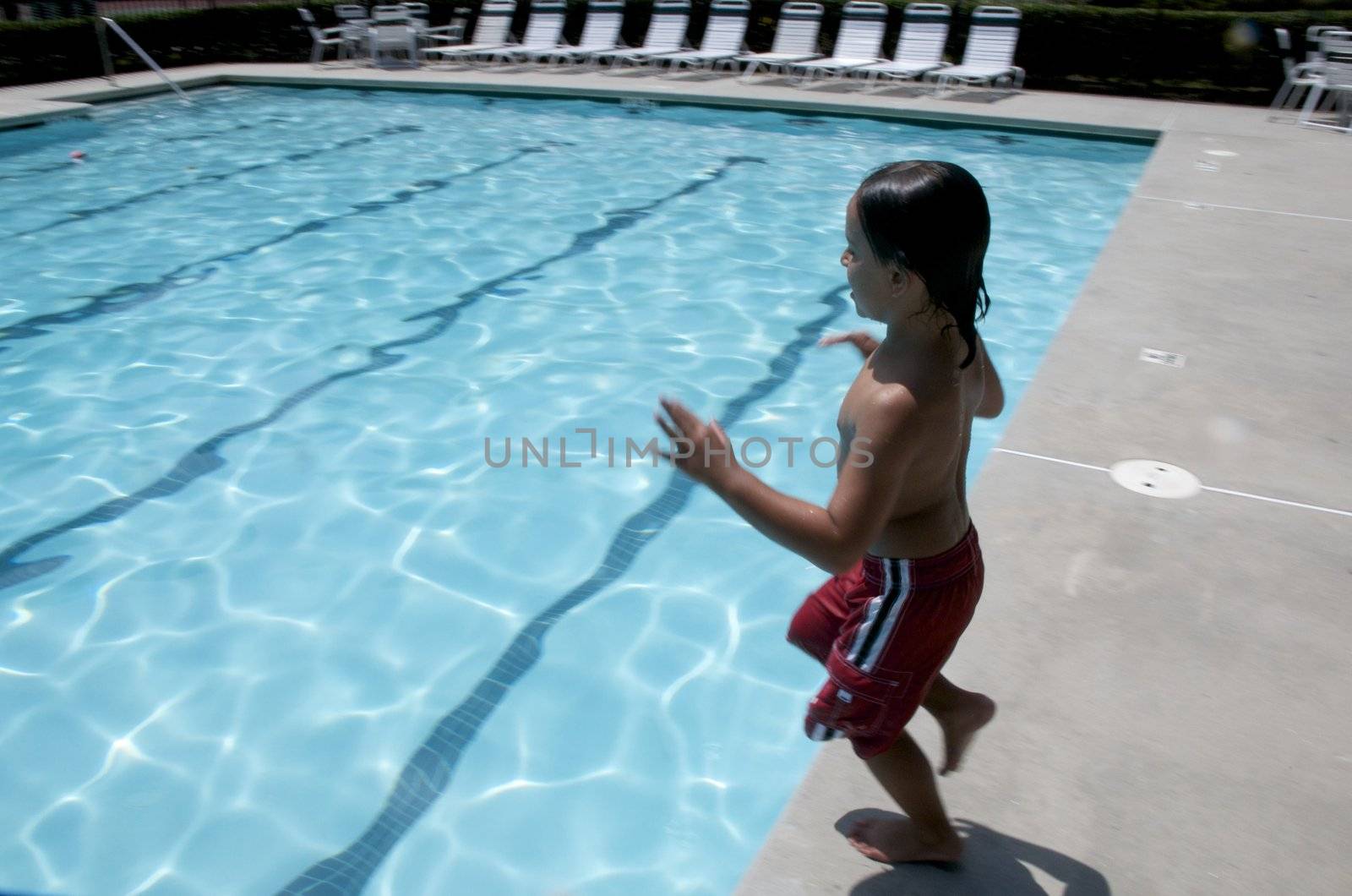 Little boy jumping into pool