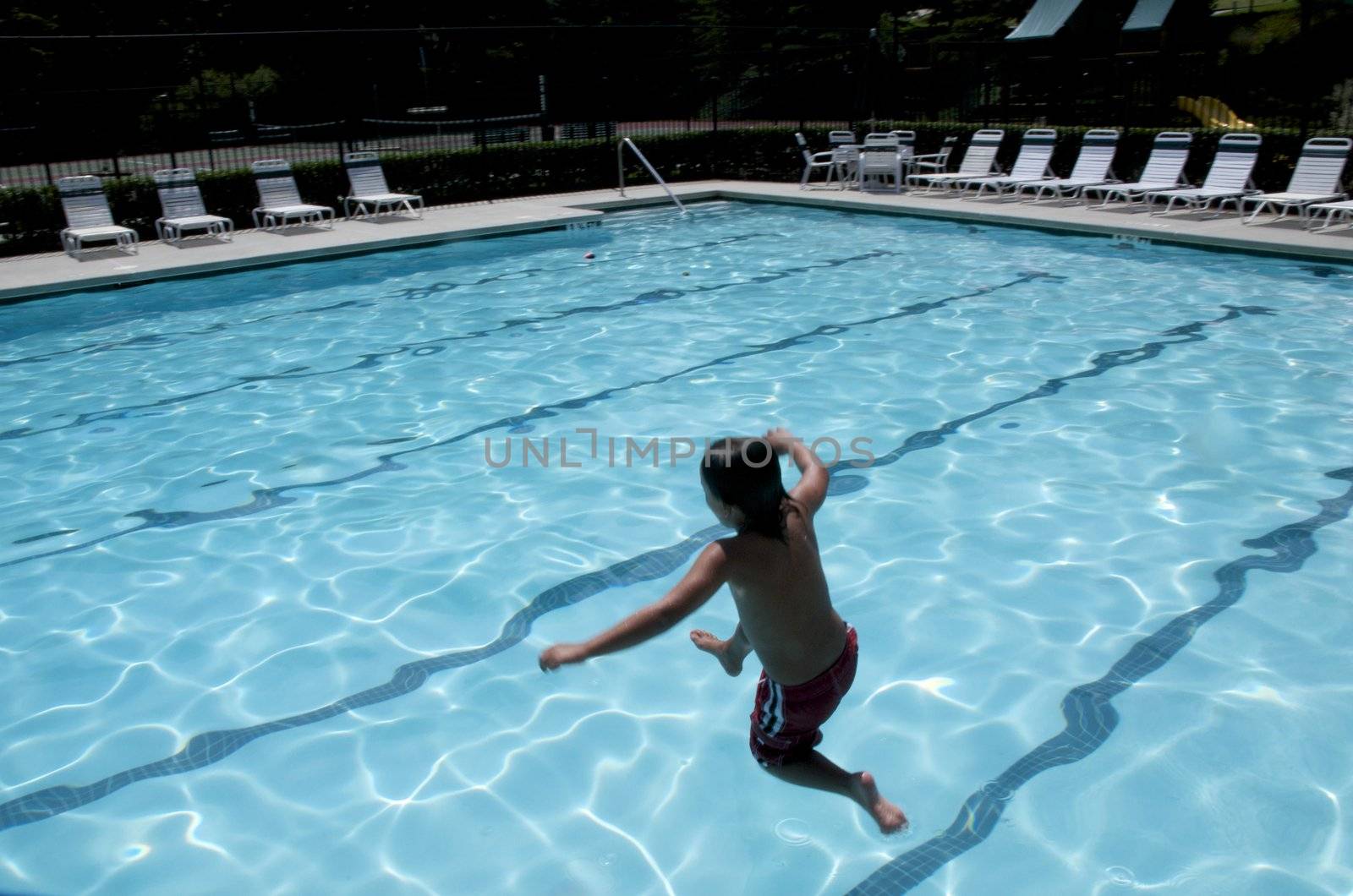 Little boy jumping into pool